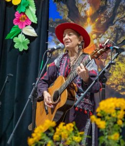 Copperwoman on stage with guitar